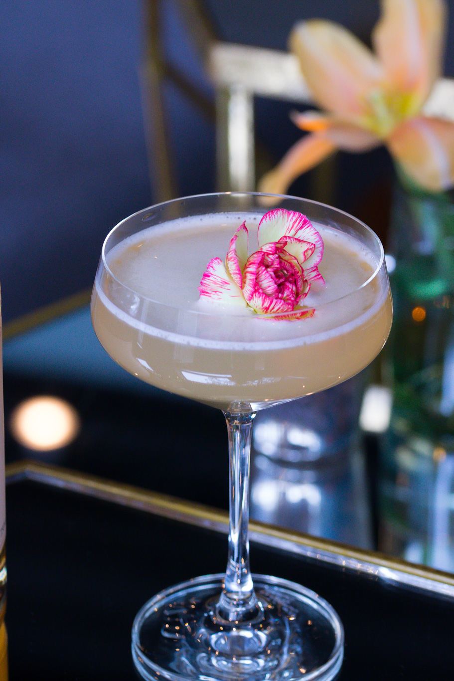 Pale sour in a coupe with an edible flower